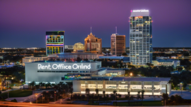 Create an image depicting a vast, modern office building in downtown Orlando with a glowing For Rent sign prominently displayed at the forefront. The city skyline, including iconic Orlando landmarks,